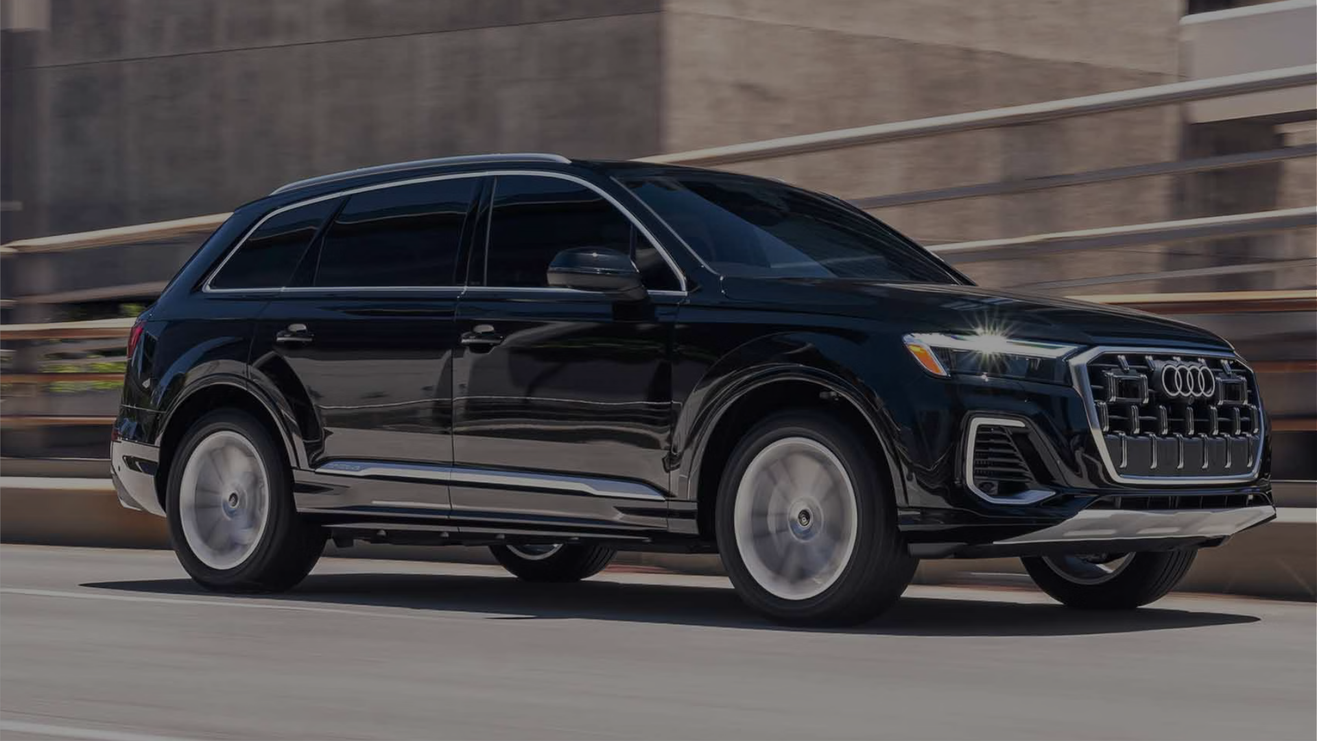 Left profile view of an Audi Q7 accelerating.